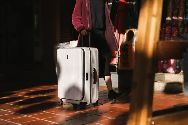 Traceur GPS ultra-compact format carte bancaire glissé dans une poche de valise
